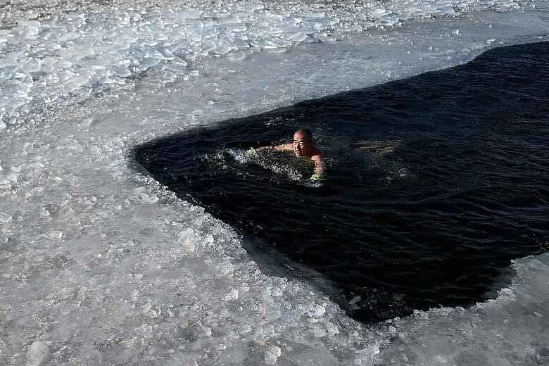 A swimmer braving the icy waters of a frozen lake in Beijing yesterday. The Chinese capital has been experiencing an unusually cold spell.