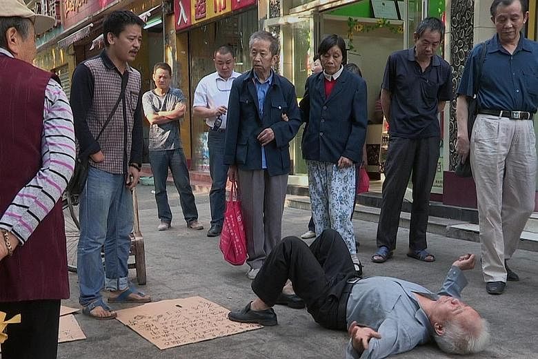 In a still from City Dream, a crowd looks on as stallholder Wang Tiancheng (on the floor) demonstrates against his eviction by the authorities in the Chinese city of Wuhan.