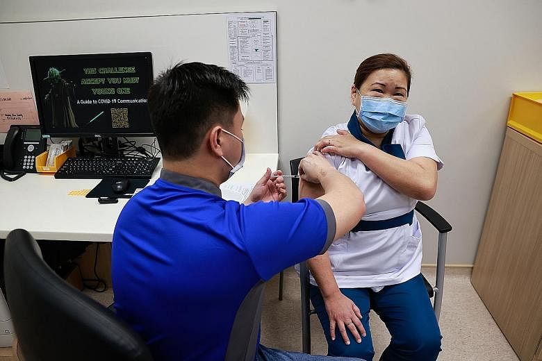 Left: NCID social medical worker Bennie Lim Youmin, 27, with her vaccination card. Below: NCID senior staff nurse Sarah Lim, 46, receiving her shot on Dec 30. Those under the age of 16 will not be getting the Covid-19 vaccine any time soon, as not en