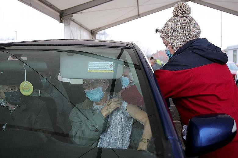 UNITED STATES People queuing up for coronavirus vaccination jabs outside a library in Lehigh Acres, Florida, on Dec 29 as the number of infections continues to surge nationwide. PHOTO: NYTIMES ARGENTINA Health workers distributing the Russian-develop
