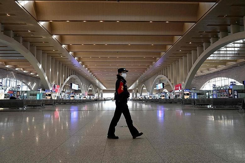A police officer patrolling an empty railway station in Shijiazhaung on Thursday. The city in China's Hebei province and a neighbouring city, Xingtai, have cut outside transport links and banned residents from leaving after detecting the country's la