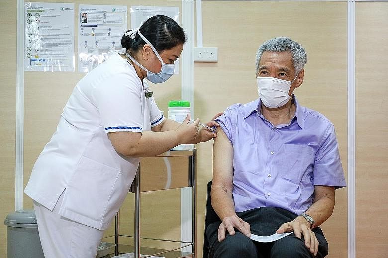 Senior staff nurse Fatimah Mohd Shah, 41, administering the vaccine shot for Prime Minister Lee Hsien Loong at Singapore General Hospital yesterday. He told reporters that it was painless, effective and important. PHOTO: LIANHE ZAOBAO