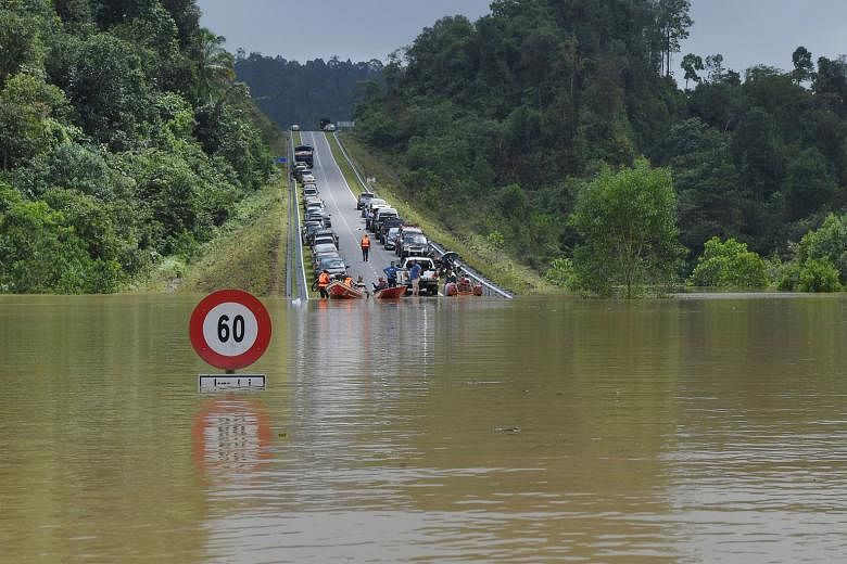 A road connecting Bandar Al-Muktafi Billah Shah in Malaysia's Terenggnau state to three villages inundated with flood water yesterday. The number of flood victims in the east coast state totalled 12,899 yesterday morning. PHOTOS: BERNAMA