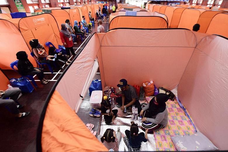 A family resting in their tent at a relief centre in Kota Tinggi, Johor, earlier this week. Thousands of such tents have been set up at more than 200 relief centres in the east coast states of Malaysia as well as eastern parts of Johor amid floods ca