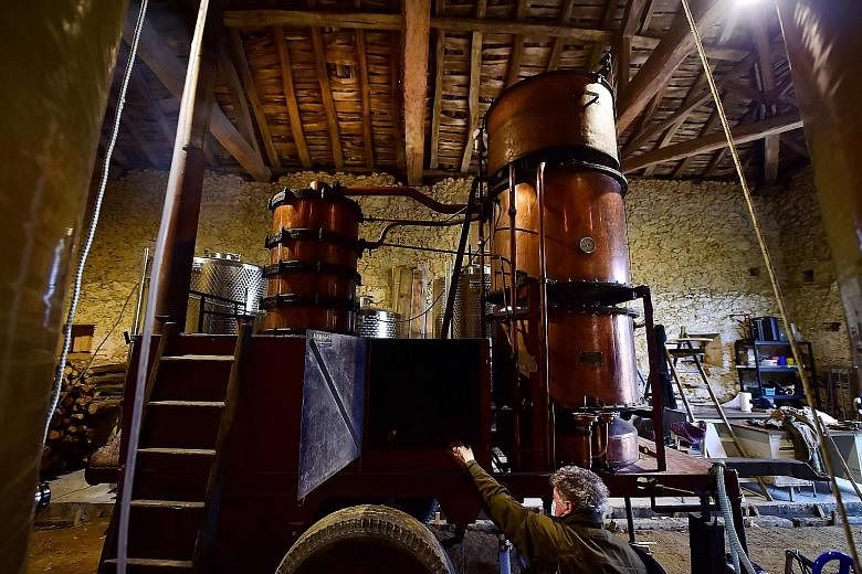 THREE GENERATIONS OF DISTILLERS: Mr Marc Saint-Martin at his old still installed in the cellar of Domaine de Tauriac in Seailles near Vic-Fezensac, in the south-west of France, last month. The Saint-Martin family have been itinerant distillers for th