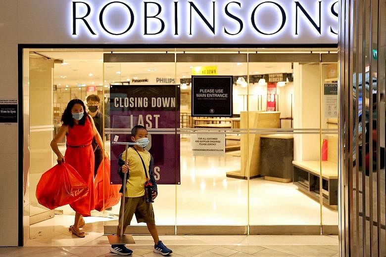 A woman, who wanted to be known only as Ms Zheng, 45, and her son were the last customers to leave Robinsons' outlet at Raffles City at 3.57pm yesterday, its last day of operation. ST PHOTO: JOEL CHAN