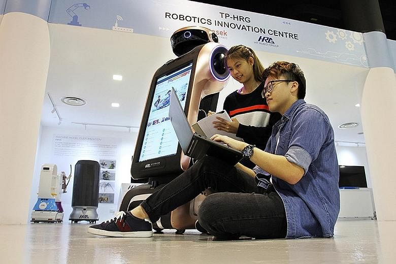 Students at the TP-HRG Robotics Innovation Centre at Temasek Polytechnic. Working adults heading to polys to upgrade their skills say they suit them better as the courses are more work-focused and shorter.