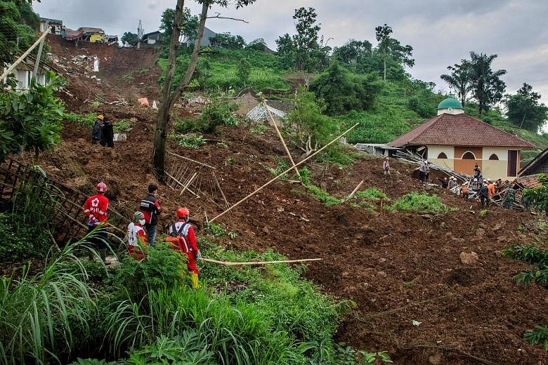 Rescuers from the Indonesian Red Cross searching for survivors yesterday after torrential rain triggered landslides in the town of Sumedang in West Java province on Saturday. Residents and a rescue team that had been searching for the initial victims