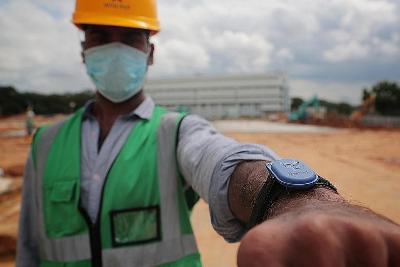 A worker with a BluePass token on his wrist at a construction site in Tampines Industrial Avenue 2 last July. The device is designed to be strapped onto a person's wrist, so that it can be worn constantly to reduce electrostatic discharge. ST FILE PH