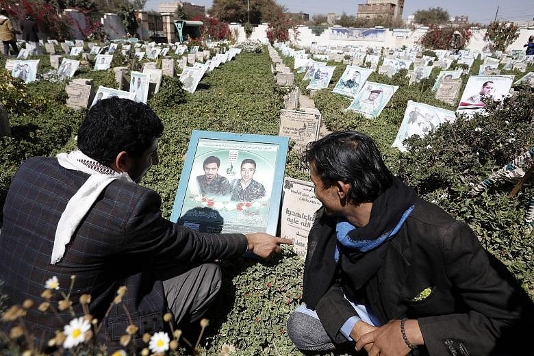 Yemenis visiting the graves of their two relatives, who were killed in the country's ongoing war, during the Houthi-held Martyr Week anniversary at a cemetery in Sanaa, Yemen, last week. The Houthi group is the de facto authority in northern Yemen an