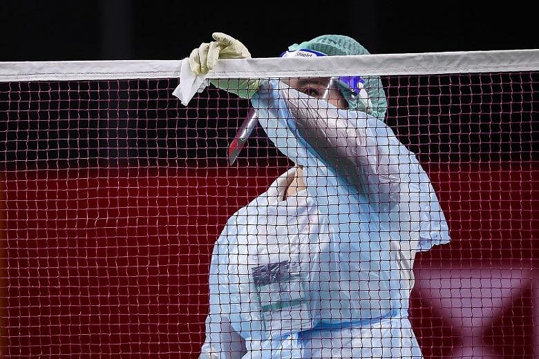 A worker in personal protective equipment sanitising the net ahead of the Yonex Thailand Open badminton tournament starting today in Bangkok.