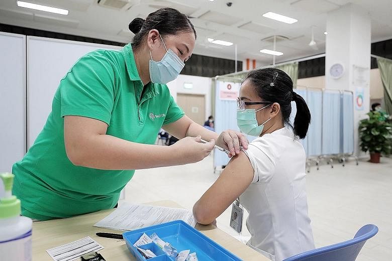 An employee at Ren Ci @ Bukit Batok Street 52 receiving the Pfizer-BioNTech Covid-19 vaccine yesterday. Fifty staff at the nursing home received the jab, and the other 110 or so employees will be vaccinated in two batches over the next two weeks.