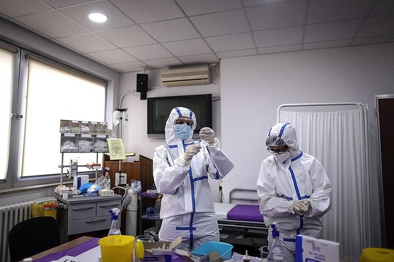 Workers preparing doses of the Pfizer-BioNTech vaccine in Serbia. The pandemic has given the world common cause to work together, says DPM Heng, with institutions cooperating across borders on treatments and vaccines.