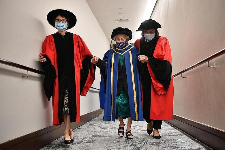 Dr Oon Chiew Seng being accompanied by Adjunct Associate Professor Helen Chen (left) and her caregiver as she was leaving the University Cultural Centre, where she received the Honorary Degree of Doctor of Letters yesterday. ST PHOTO: CHONG JUN LIANG