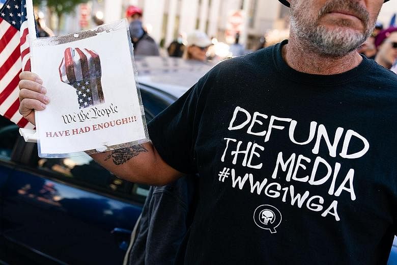 A QAnon conspiracy theory supporter wearing a "Defund the media" QAnon shirt at a "Stop the steal" rally against the results of the US presidential election outside Georgia's state capitol in Atlanta on Nov 18 last year.
