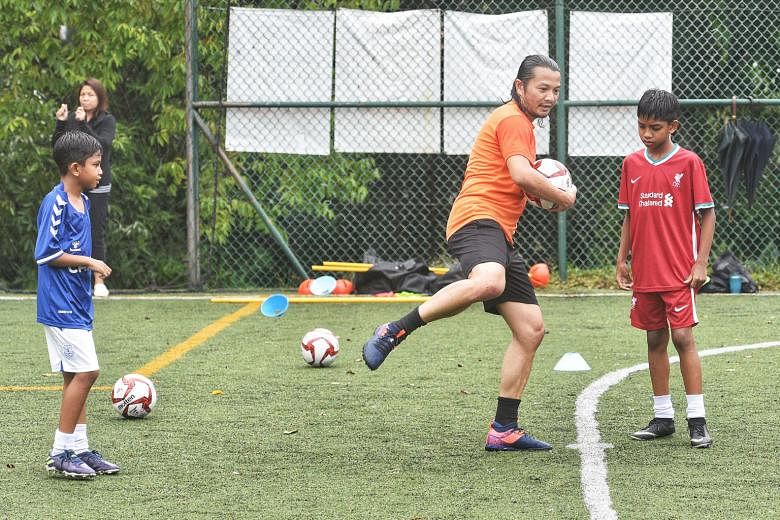 Indra Sahdan Daud, 41, coaching Kyen Sasikumar, nine, and his seven-year-old brother Tylan (far left) at The Arena at Woodleigh Park. The former national striker has scored against the likes of Manchester United, Japan, Uruguay and Denmark during his