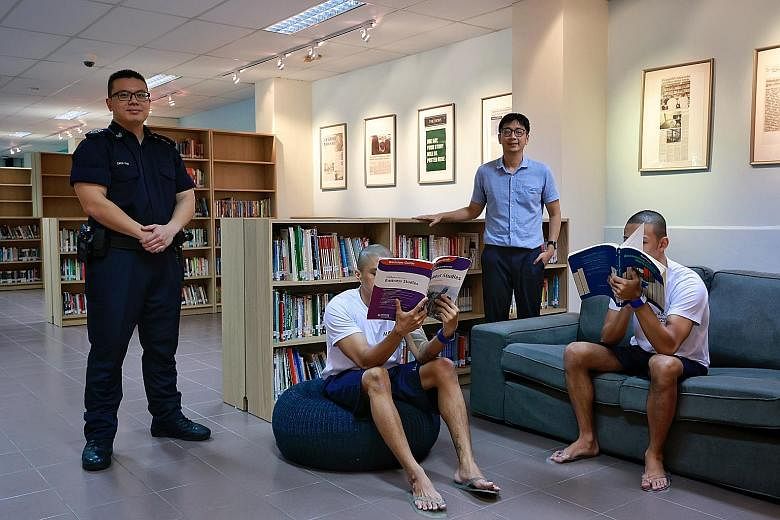 Minister of State for Home Affairs and National Development Muhammad Faishal Ibrahim speaking to an inmate at Tanah Merah Institution 1 on Tuesday. Inmates Azly (seated, left) and David (not their real names) received their O-level results on Monday 