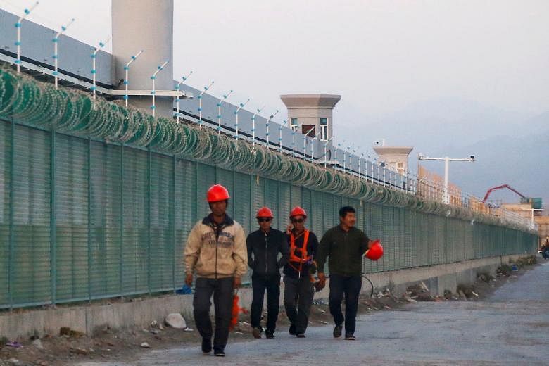 A 2018 photo of workers walking past what is officially known as a vocational skills education centre in Xinjiang. Beijing says such centres operate to counter Islamist radicalism following a series of attacks it attributed to the Uighurs. PHOTO: REU