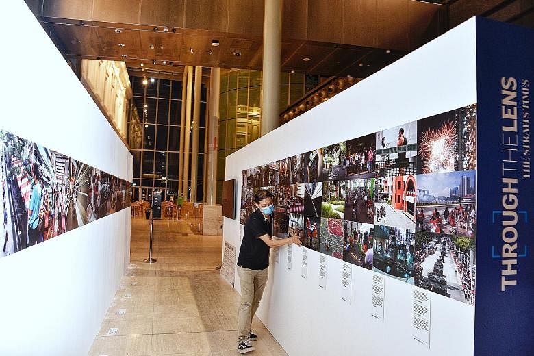 An employee setting up an exhibit last night at Through The Lens, a photography exhibition by The Straits Times and World Press Photo (WPP). It will feature ST photojournalists' coverage of the Covid-19 pandemic here, as well as photos submitted for 