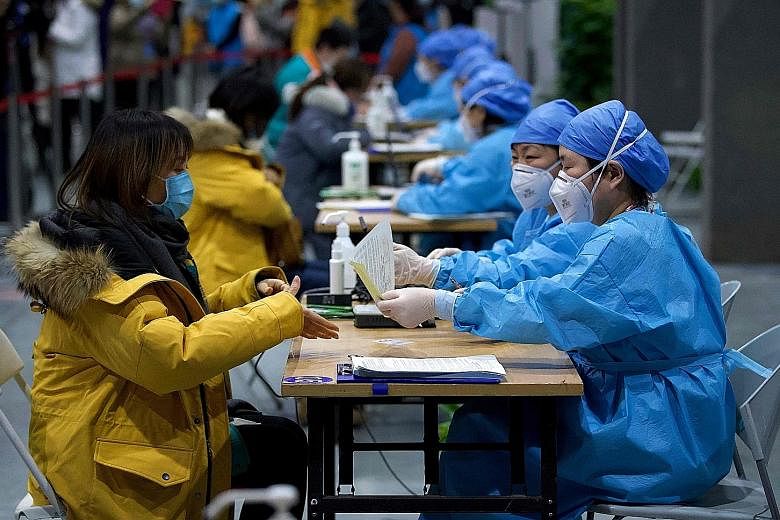 Medical workers registering people for Covid-19 vaccination in Beijing yesterday. Thousands of vaccination centres have been set up across the country, and more than a million people have been inoculated in the Chinese capital alone.