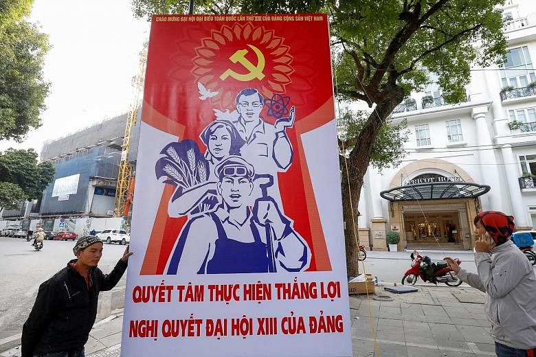 Workers in Hanoi putting up a poster for the ruling Communist Party of Vietnam's upcoming National Congress on Tuesday. The congress, due to be held from Jan 25 to Feb 2, is a five-yearly affair that sets the country's socio-economic direction and an
