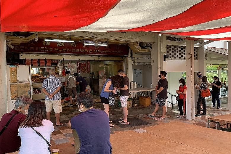 While the pandemic has dampened demand for many businesses, Sang Hock Guan - a bak kwa stall in Ang Mo Kio that accepts only walk-in orders - had a queue of 20 customers waiting when it opened yesterday. Shoppers queueing up yesterday to enter the an