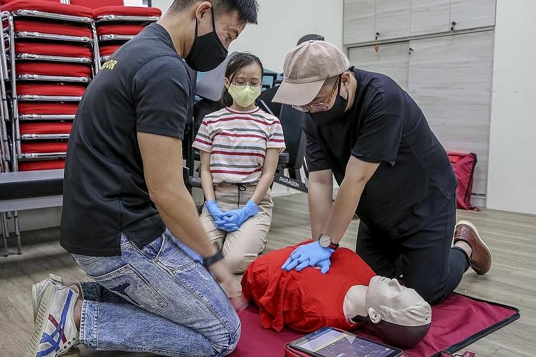 People learning how to administer cardiopulmonary resuscitation (CPR) using the new female manikin vest at the Singapore Heart Foundation last Friday. Traditionally, CPR training is taught with manikins with a male physique. The manikin vests were di