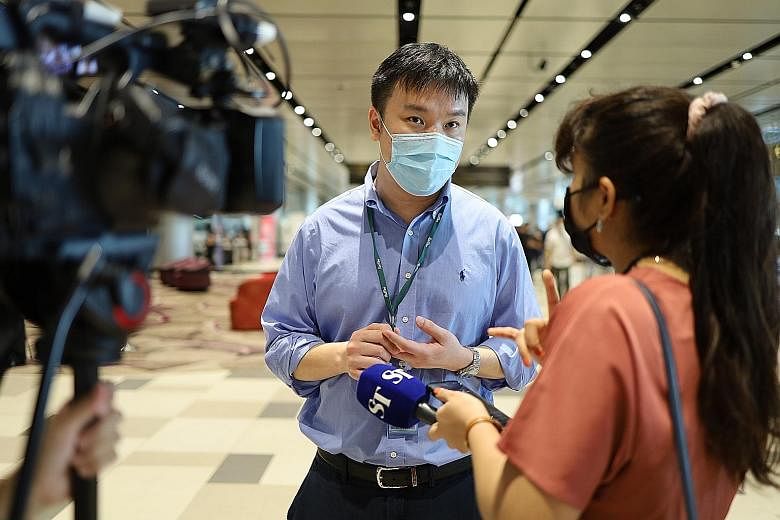 The vaccination centre's lead physician Tan Joo Peng said there is scope to ramp up capacity even further. Above: Front-line workers from the aviation industry receiving the Covid-19 vaccine at Changi Airport Terminal 4 yesterday. Below: Workers regi
