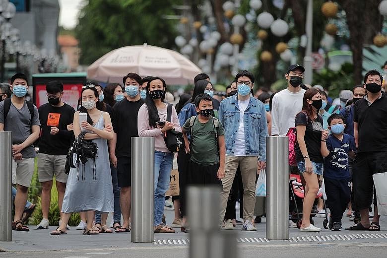 Pedestrians at a traffic junction in Orchard Road last month. Along with the four community cases reported yesterday, there were also 26 imported cases.