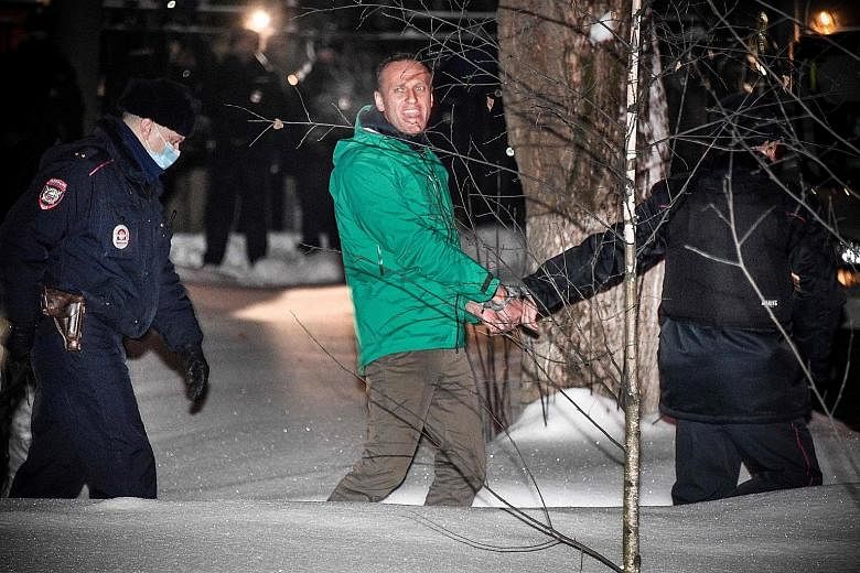 Alexei Navalny being escorted out of a police station in Khimki, outside Moscow, following Monday's court ruling that ordered his detention for 30 days. His detention came a day after his return to Russia for the first time since he was poisoned with