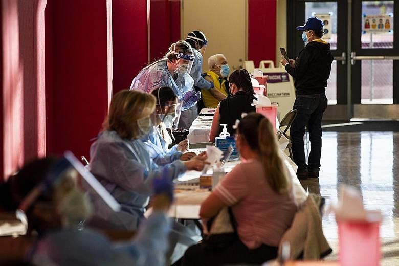 People getting the Moderna vaccine at the Corona High School in Riverside County in California last Friday. The state halted its vaccination programme on Sunday, after several people who received the vaccine at one community clinic needed medical att