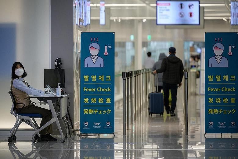 A health worker screening passengers at South Korea's Incheon International Airport, which processed 11.96 million passengers last year, putting it at the top of the list for the first time, although with drastically fewer numbers than in previous ye