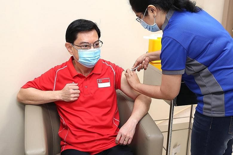 Deputy Prime Minister Heng Swee Keat receiving the Covid-19 vaccine jab from nurse manager Imrana Banu at the National Centre for Infectious Diseases yesterday.