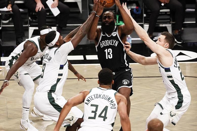 Brooklyn guard James Harden is surrounded by the Milwaukee defence as he drives to the basket in their NBA game at the Barclays Centre on Monday. He had 34 points and 12 assists in the 125-123 win. Keeping his star trio of Harden, Kevin Durant and Ky
