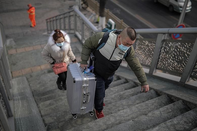 Travellers at a Beijing railway station on Tuesday. Those heading to rural villages will have to go through a 14-day isolation period as new cases of Covid-19 keep China on edge ahead of Chinese New Year. PHOTO: EPA-EFE