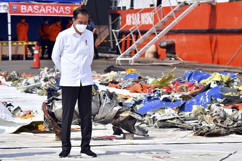 Indonesian President Joko Widodo beside the debris of Sriwijaya Air Flight SJ182 recovered from waters off Jakarta, during a visit to Tanjung Priok port in the country's capital on Wednesday.