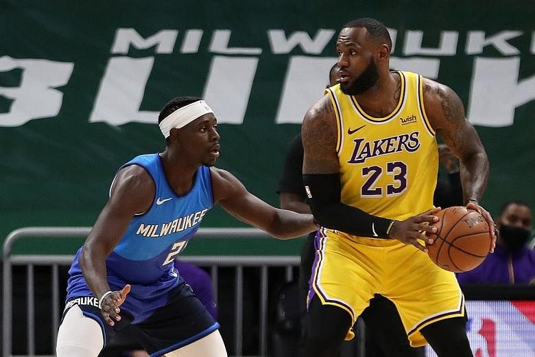 LeBron James, guarded by Bucks' Jrue Holiday, scored a season-high 34 points as the Lakers won their eighth straight away game.