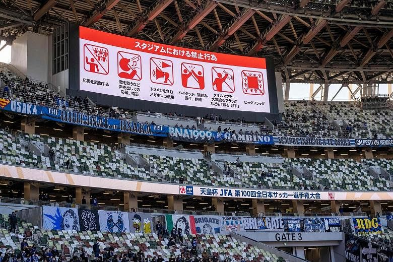 Don't cheer, talk loudly, eat, drink, or wave flags, signs on a billboard warn the restricted crowd at a football final in Tokyo on Jan 1. This is the likely experience awaiting fans at the Tokyo Olympics - if they can get in at all provided the Game