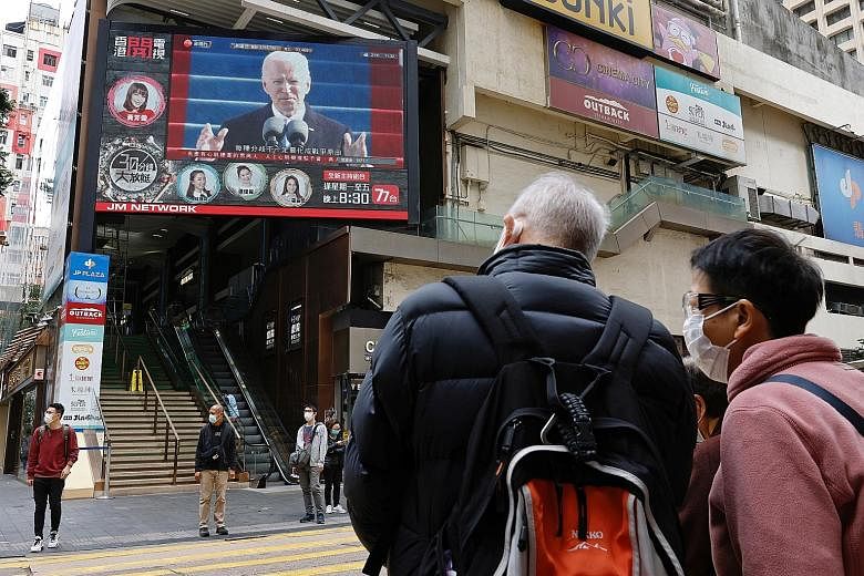 Above: A big screen in Hong Kong showing US President Joe Biden after his inauguration this week. Beijing hopes he will reverse sanctions on Hong Kong and Chinese officials for railroading the national security law in the territory. Below: Beijing's 