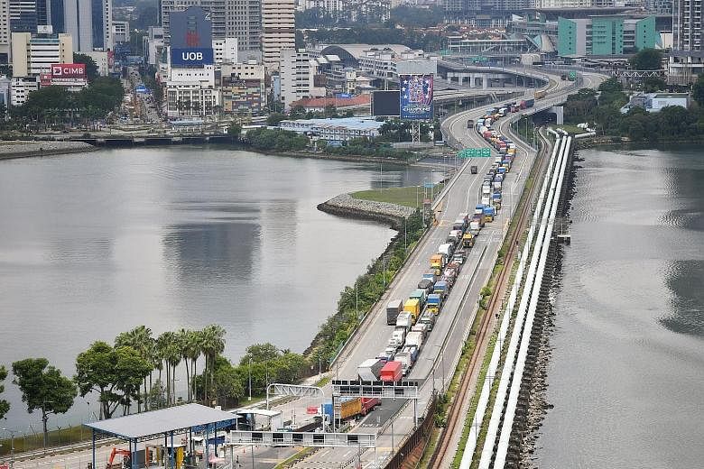 Cargo vehicles waiting to enter Singapore via the Causeway yesterday, when compulsory antigen rapid tests were rolled out at the Tuas and Woodlands checkpoints. The Health Ministry's director of medical services Kenneth Mak said testing operations ha