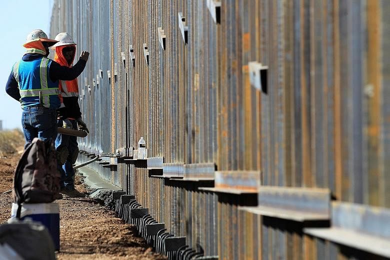 Men working on a wall ordered by former US president Donald Trump near Columbus County, New Mexico (US) on Dec 2. Several Democrats are pushing for President Joe Biden's bid to revamp the immigration policy. PHOTO: EPA-EFE