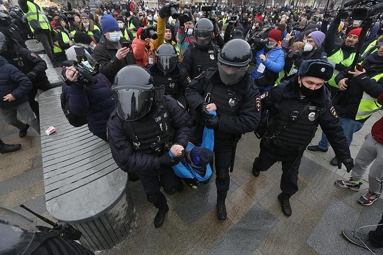 Police in full riot gear beating protesters with batons yesterday in Vladivostok, where demonstrators had congregated in the city centre, chanting "Putin is a thief" and "Freedom to Navalny". Above: People in Omsk, Siberia, heeding Kremlin critic Ale