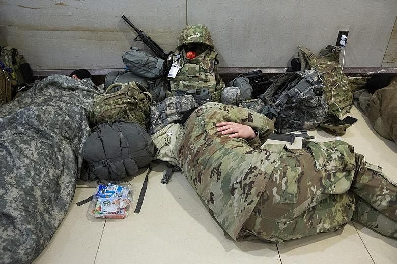 Members of the National Guard resting in the Capitol Visitor Centre on Capitol Hill in Washington on Friday. Photographs of troops sleeping on the floor of an unheated carpark on Thursday have sparked an uproar. PHOTO: EPA-EFE
