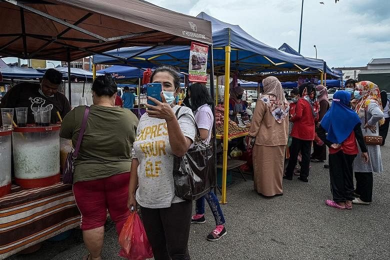  People visiting a market in Karak, in Pahang, last Wednesday, ahead of the market's final night before it closed to curb the spread of the coronavirus. 