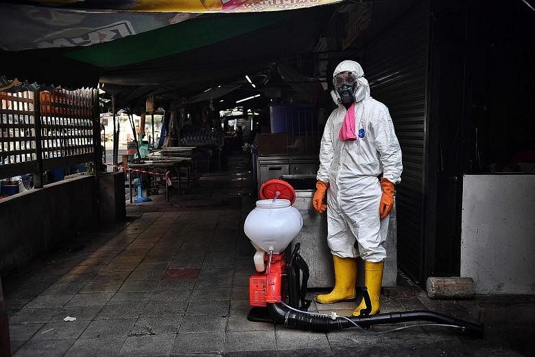 A man preparing to spray disinfectant around Klong Toey fresh market, after it was temporarily shut down due to several vendors testing positive for Covid-19, in Bangkok on Jan 14.