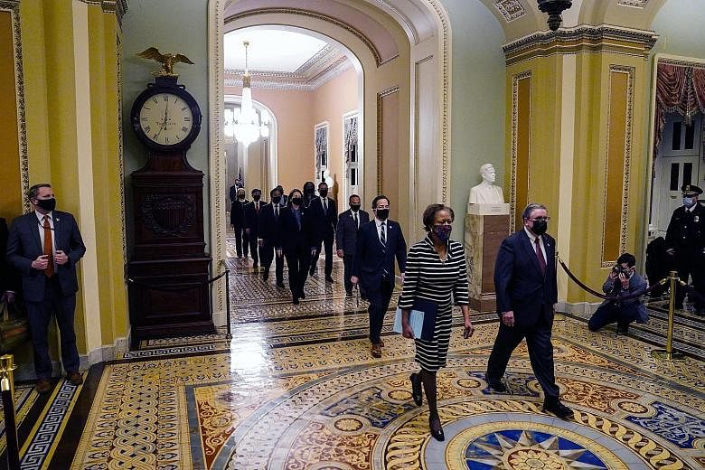Nine House Democrats, who will serve as prosecutors in Mr Donald Trump's trial, accompanied by the Clerk of the House and the acting Sergeant-At-Arms, carrying the charge against the former president to the Senate Chamber in a solemn procession on Mo