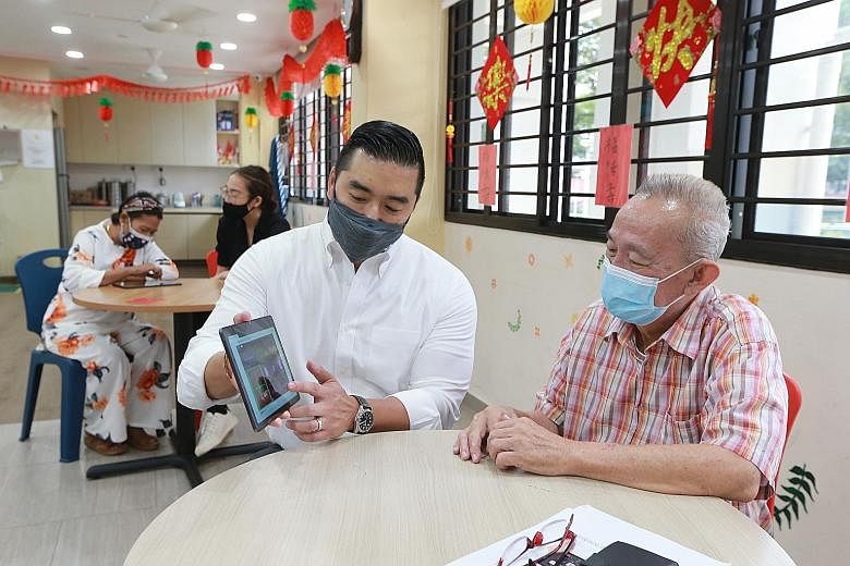 Professor Dean Ho from Yong Loo Lin School of Medicine's Institute for Digital Medicine explaining the game to Mr Lee Keng Wee, 70, at the Sunlove Marsiling Senior Activity Centre yesterday.