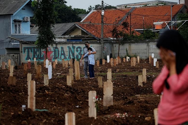 Mourners at Srengseng Sawah cemetery complex, a burial area in Jakarta provided by the government for Covid-19 victims, on Monday. 