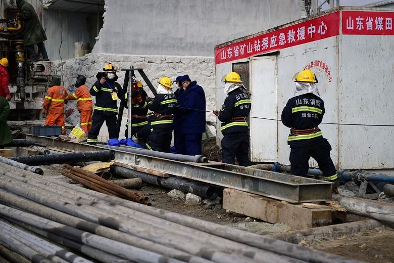 Rescue workers at the site of a gold mine explosion where 22 miners were trapped underground, in Qixia, China, last Wednesday. Eleven of them were rescued yesterday. 