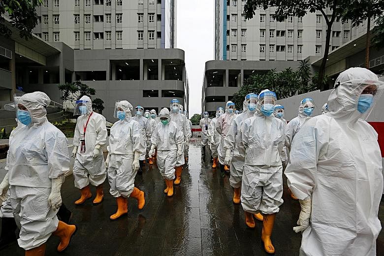 Healthcare workers wearing personal protective equipment preparing to treat patients at the athletes' village converted into an emergency hospital for Covid-19 in Jakarta on Tuesday. PHOTO: REUTERS